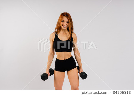 Portrait of seductive young woman looking at camera with muscular body ready for a workout Portrait of seductive young woman looking at camera with muscular body ready for a workout 84306518