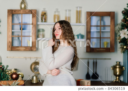 Happy emotional surprised young woman by Christmas tree in cozy living room, concept of happiness Happy emotional surprised young woman by Christmas tree in cozy living room, concept of happiness 84306519