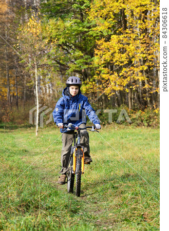 Kid cycling in a park Kid cycling in a park 84306618