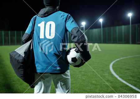 Rear view of football player with bag and soccer ball 84306958