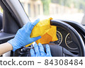 Hands with gloves wiping car steering wheel 84308484