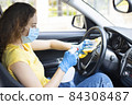 Young woman disinfecting her car 84308487