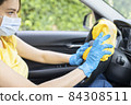 Young woman disinfecting her car 84308511