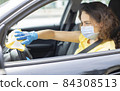 Young woman disinfecting her car 84308513