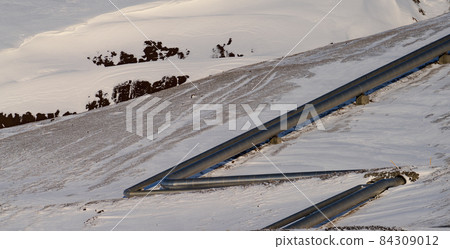 Aluminium pipes over the snow covered mountain 84309012