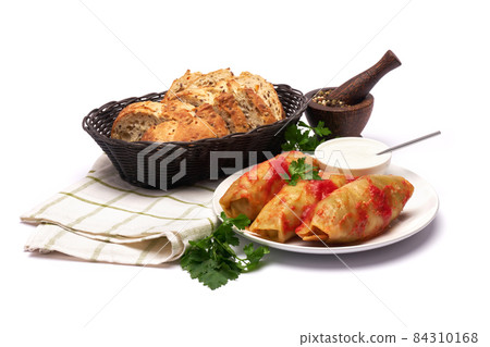 Portion of cabbage rolls stuffed with ground beef and rice with sour cream on a plate Portion of cabbage rolls stuffed with ground beef and rice with sour cream on a plate 84310168