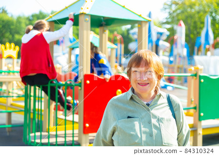 Grandmother with her young granddaughters outdoors Grandmother with her young granddaughters outdoors 84310324