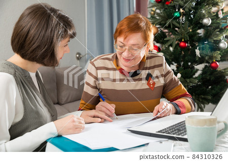 Elderly woman consult an insurance agent at home 84310326
