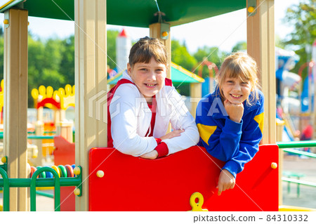 Portrait Of happy girlfriends playing outdoors on playground 84310332