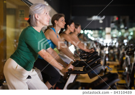 Mature woman taking cycling class at gym 84310489