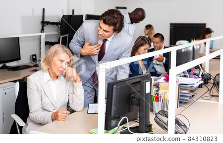 Annoyed boss scolding mature female subordinate pointing out shortcomings and misses in work 84310823