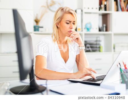 Tired businesswoman working with documents in office Tired businesswoman working with documents in office 84310948