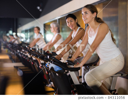 Woman taking indoor cycling class at gym 84311056