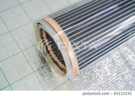 A roll of film underfloor heating lies on the insulation 84312242