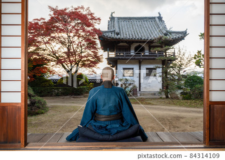 一位僧人用秋葉做冥想 84314109