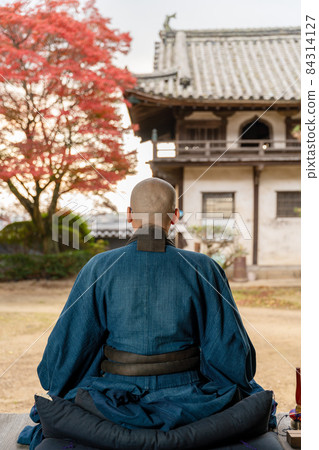 一位僧人用秋葉做冥想 84314127