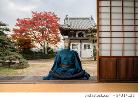 一位僧人用秋葉做冥想 84314128