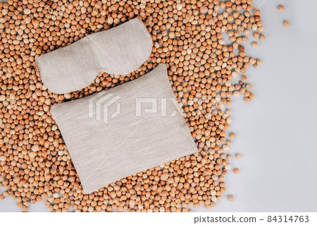 Cherry stone pillow for spa massage and eye mask with cherry stones, cherry pit filled pillow on cherry stones background. Natural heat or cool pack. Alternative medicine and therapy. Copy space Cherry stone pillow for spa massage and eye mask with cherry stones, cherry pit filled pillow on cherry stones background. Natural heat or cool pack. Alternative medicine and therapy. Copy space 84314763