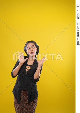woman with Kebaya dress with surprised gesture with both palms open 84314912