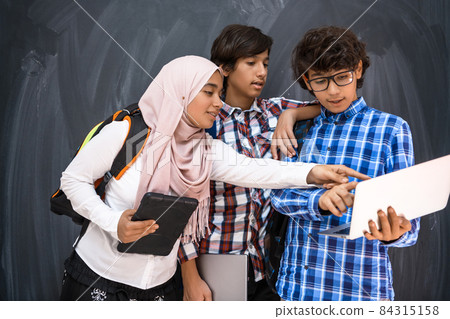 Arabic teenagers team, students group working together on laptop and tablet computer online classroom education concept 84315158