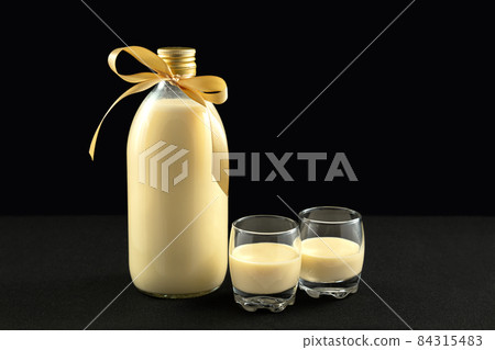 Homemade eggnog in bottle and two glasses with Christmas cookies Homemade eggnog in bottle and two glasses with Christmas cookies 84315483