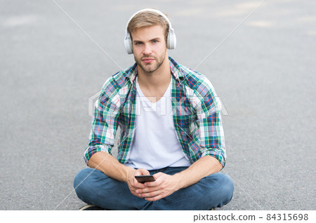 Working Online. man sit on ground. student in headset.  84315698