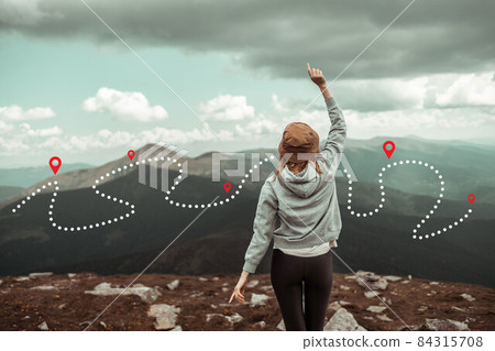 Mountain progression path. Traveling female traveler explorer stands on top of a mountain and enjoys the view of the mountains. Mountain progression path. Traveling female traveler explorer stands on top of a mountain and enjoys the view of the mountains. 84315708