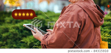 Excellent. Woman using mobile phone with icon five star symbol to increase rating of company, customer service 84315910