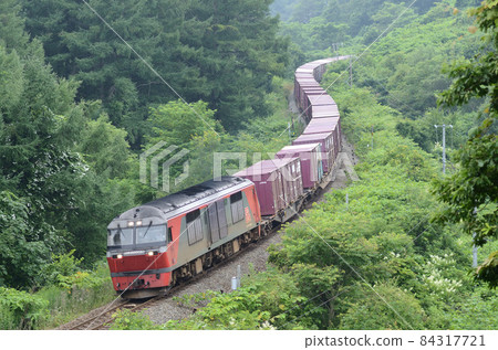 A freight train that bends down an S-shaped curve and carefully descends a slope 84317721
