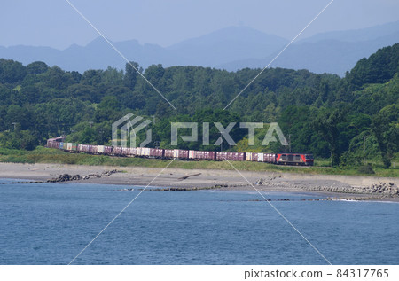 A freight train that appeared on the Usu coastline with the faintly floating mountains of Toya in the background A freight train that appeared on the Usu coastline with the faintly floating mountains of Toya in the background 84317765