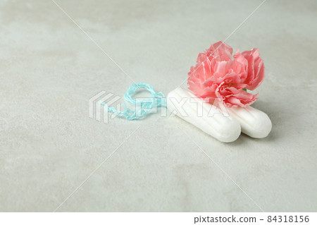 Tampons and flower on white textured background 84318156