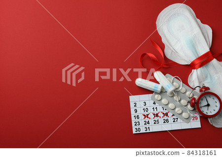 Concept of menstruation on red background, space for text 84318161