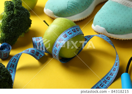 Healthy lifestyle accessories on yellow background, close up 84318215