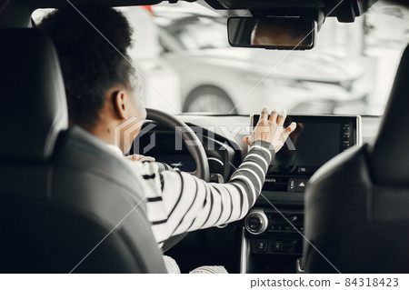 Young african american woman in car salon Young african american woman in car salon 84318423