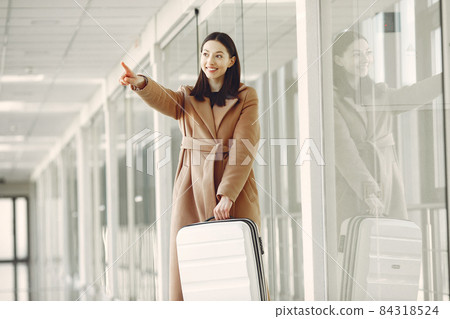 Woman with suitcase at the airport Woman with suitcase at the airport 84318524