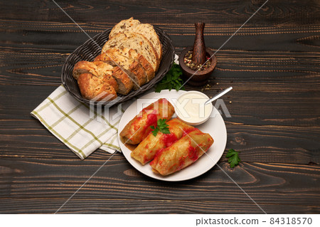 Portion of stuffed cabbage rolls on wooden table 84318570