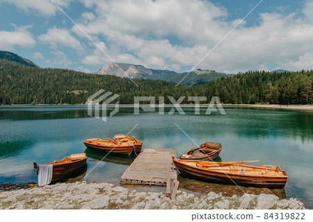 Boats on Black Lake - Crno jezero , northern Montenegro. It is a glacial lakeon the Mount Durmitor, on an altitude of 1,416 m. Black lake in Durmitor national park in Montenegro, Europe. Beauty world. Boats on Black Lake - Crno jezero , northern Montenegro. It is a glacial lakeon the Mount Durmitor, on an altitude of 1,416 m. Black lake in Durmitor national park in Montenegro, Europe. Beauty world. 84319822
