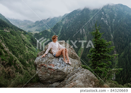 Girl on the cliff edge near Transfegerasan mountain road. Girl on the cliff edge near Transfegerasan mountain road. 84320669