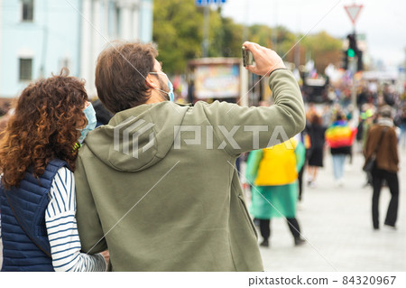 Couple taking a selfie during a march in support of LGBTQ rights. 84320967