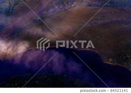 Aerial view of a beautiful summer landscape with a fog while dawn. Photo from drone of a foggy landscape in spring. Top view to land while sunrise. Early morning in nature, misty weather. Aerial view of a beautiful summer landscape with a fog while dawn. Photo from drone of a foggy landscape in spring. Top view to land while sunrise. Early morning in nature, misty weather. 84321141