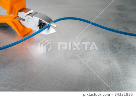 Electrical hand tool cut cable on grunge metal background 84321856