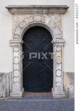 Old steel door with decorative stone portal Old steel door with decorative stone portal 84322177