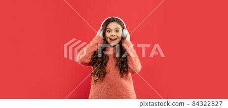 amazed child in sweater listen music in headphones, music 84322827