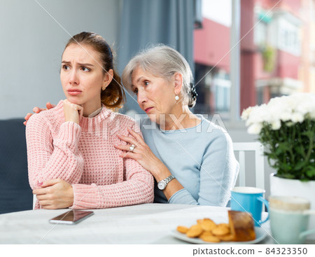 Mother encouraging her depressed adult daughter 84323350