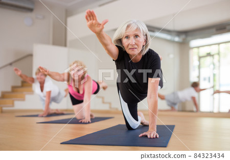 Mature women exercising hands and knees balance 84323434