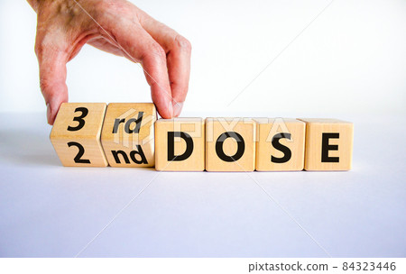 Covid-19 booster dose vaccine shot symbol. Doctor turns cubes and changes words '2nd dose' to '3rd dose'. Beautiful white background, copy space. Covid-19 booster dose vaccine shot concept. Covid-19 booster dose vaccine shot symbol. Doctor turns cubes and changes words '2nd dose' to '3rd dose'. Beautiful white background, copy space. Covid-19 booster dose vaccine shot concept. 84323446