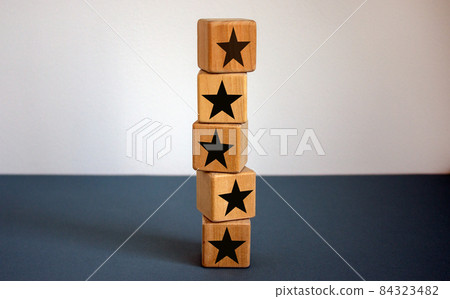 Wood cubes with star sign on beautiful blue table, copy space. White background. Quality and luxury conceptual image. Wood cubes with star sign on beautiful blue table, copy space. White background. Quality and luxury conceptual image. 84323482