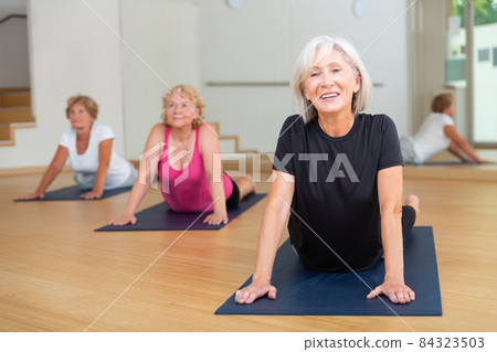 Group of elderly women performs an exercise in the dog pose face up 84323503