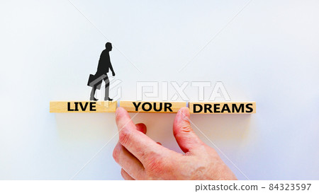 Live your dreams symbol. Wooden blocks with words 'Live your dreams'. Beautiful white background, businessman hand, businessman icon. Business, live your dreams concept, copy space. Live your dreams symbol. Wooden blocks with words 'Live your dreams'. Beautiful white background, businessman hand, businessman icon. Business, live your dreams concept, copy space. 84323597