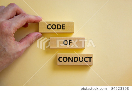 Code of conduct symbol. Concept words 'Code of conduct' on wooden blocks on a beautiful white background. Businessman hand. Business and code of conduct concept. Copy space. 84323598